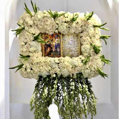 Large white floral frame around a religious icon with trailing greenery