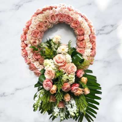 Pink and cream rose floral wreath with a matching bouquet at the base