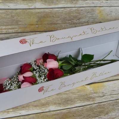 Boxed bouquet of red and pink roses with baby's breath