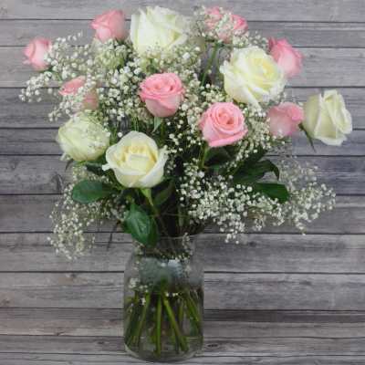 Pink and white roses arranged in a glass vase