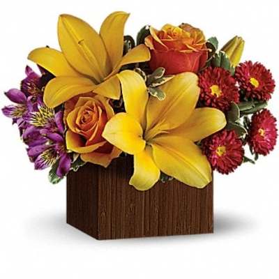Yellow lilies and orange roses in a wooden cube vase