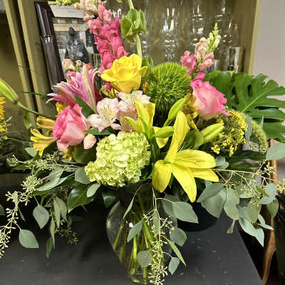 Mixed bouquet of pink and yellow flowers in a glass vase
