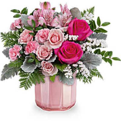 Pink roses and carnations arranged in a pink glass vase