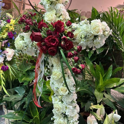 Cross-shaped floral tribute with white and red roses