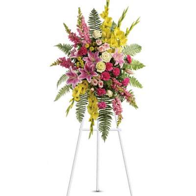 Tall floral standing spray with pink, yellow, and white blooms on an easel