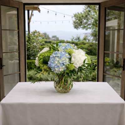 Blue and white hydrangea arrangement in a glass vase