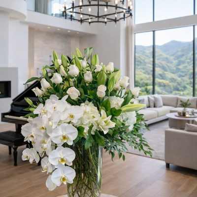 Large white floral arrangement in a clear glass vase