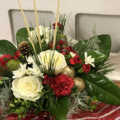 Holiday floral arrangement with white roses, red carnations, and gold ornaments