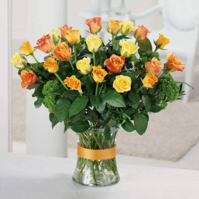 Bouquet of yellow and orange roses in a clear glass vase