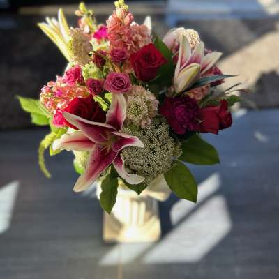 Bouquet of pink and red roses with lilies in a wrapped base