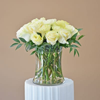 White roses arranged in a clear glass vase