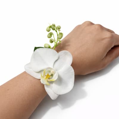 White orchid wrist corsage on a person's wrist