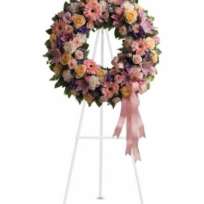Floral wreath on a white easel with a pink ribbon