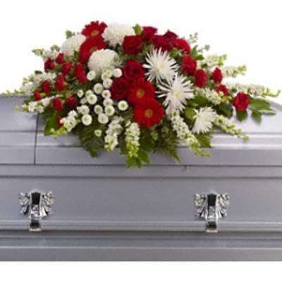 Red and white floral spray on a gray casket