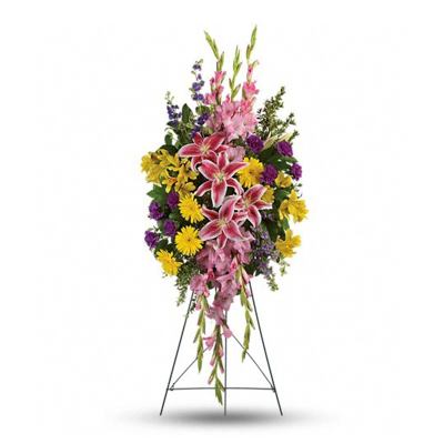 Standing floral spray with pink lilies, yellow daisies, and purple accents on an easel