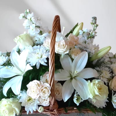White floral basket arrangement with lilies, roses, and daisies