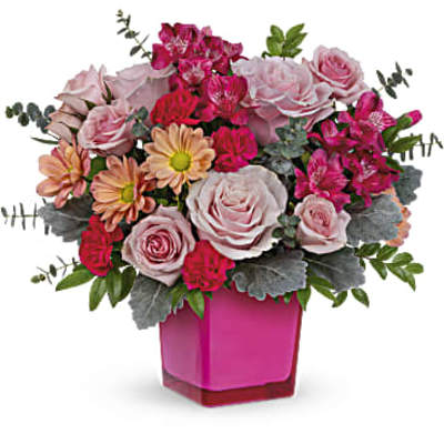 Pink and peach flower arrangement in a magenta vase