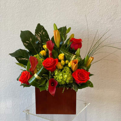 Red roses and calla lilies arranged in a wooden box