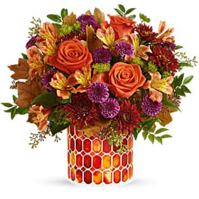 Autumn bouquet of orange roses and purple flowers in a patterned vase