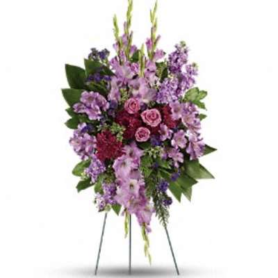 Standing floral spray with purple flowers and pink roses on a wire easel