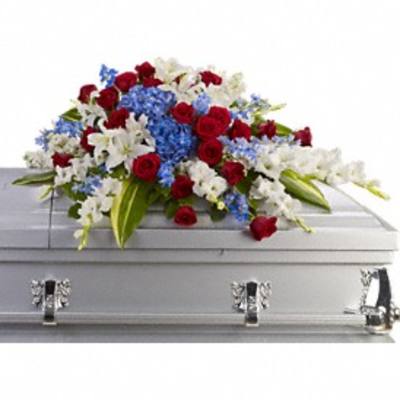Red, white, and blue floral spray on a silver casket