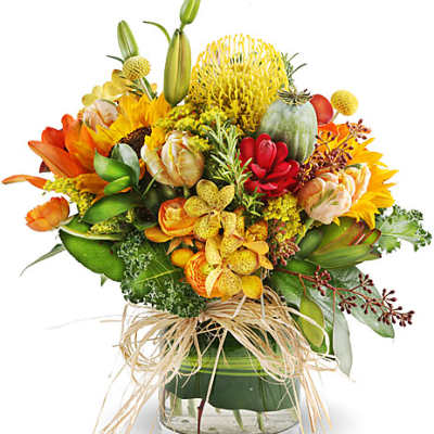 Colorful bouquet in a clear glass vase with sunflowers and lilies