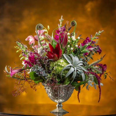 Colorful mixed flower arrangement in a silver pedestal vase