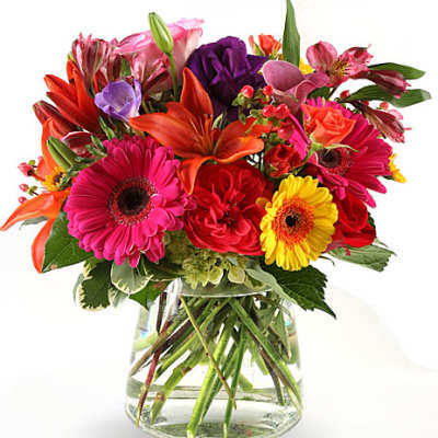Mixed bouquet of bright flowers in a clear glass vase