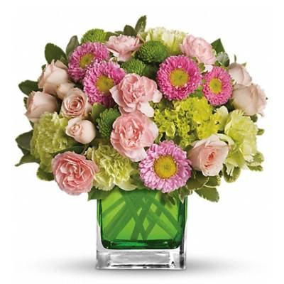 Pink and green mixed bouquet in a square glass vase