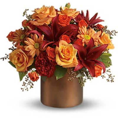 Orange and red floral arrangement in a bronze vase