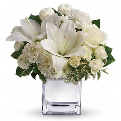 White flowers arranged in a clear square vase