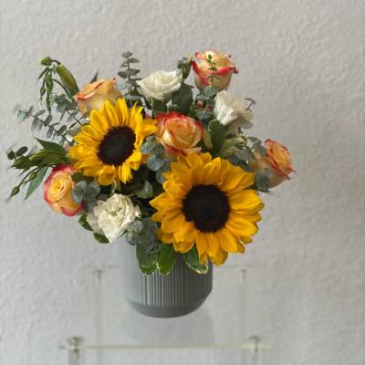 Sunflower and rose bouquet in a gray vase