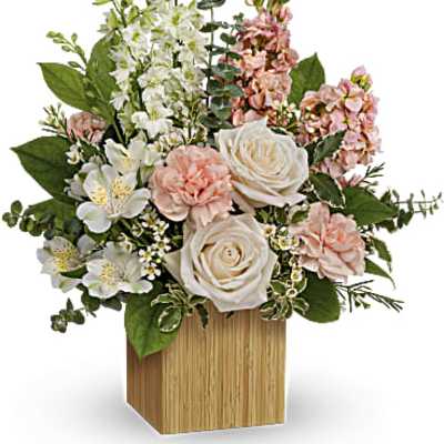 Pink and white floral arrangement in a wooden cube vase