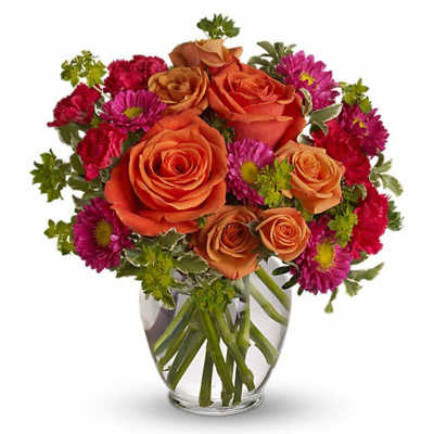 Orange roses and magenta daisies in a clear glass vase