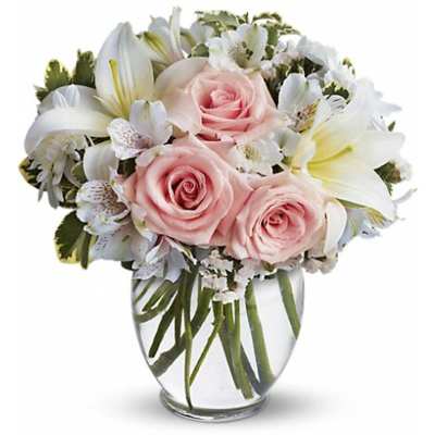 Pink roses and white lilies in a clear glass vase