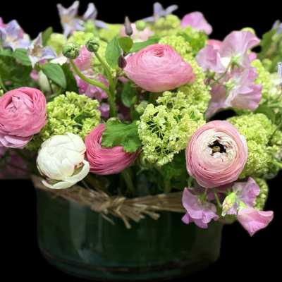 Pink and white flowers arranged in a green vase