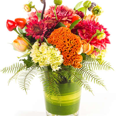 Colorful mixed bouquet in a glass vase with orange and pink blooms