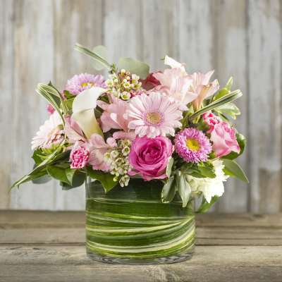 Pink mixed flowers arranged in a glass vase
