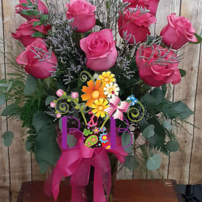 Pink roses arranged in a vase with a ribbon bow