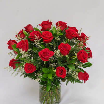 Red roses arranged in a clear glass vase