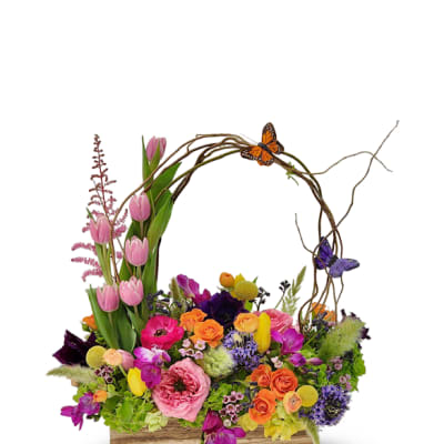 Colorful mixed flower arrangement in a wooden box with butterfly accents