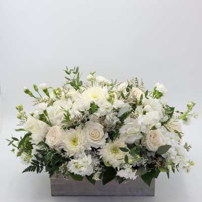 White floral arrangement in a rectangular gray container