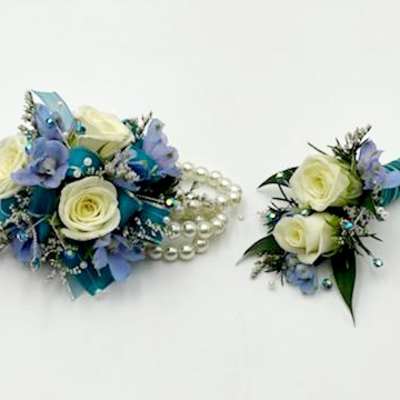 Two small floral pieces with white roses and blue accents, one with pearl strands