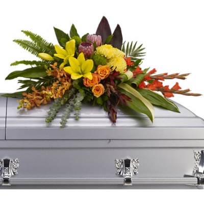 Bright mixed floral casket spray arranged on a silver casket