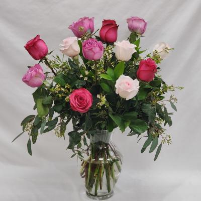 Pink and white roses arranged in a clear glass vase