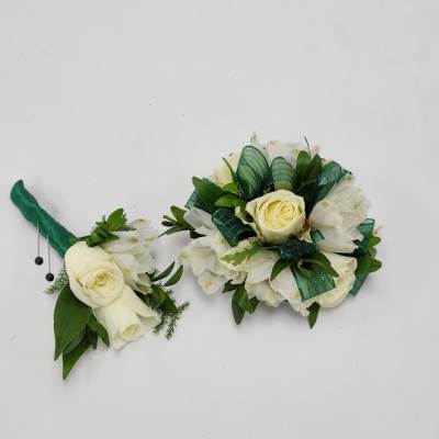 Two white rose boutonnieres with green ribbon accents