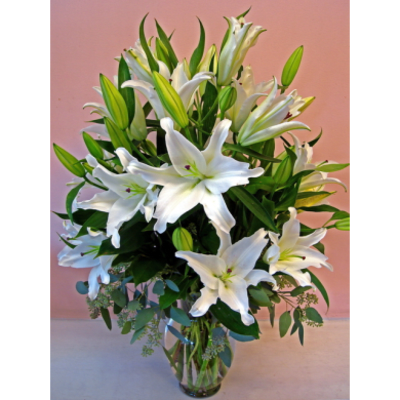 White lilies arranged in a clear glass vase