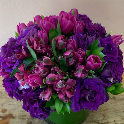 Purple and pink bouquet in a green vase
