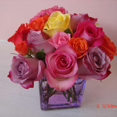Mixed roses in a purple glass vase