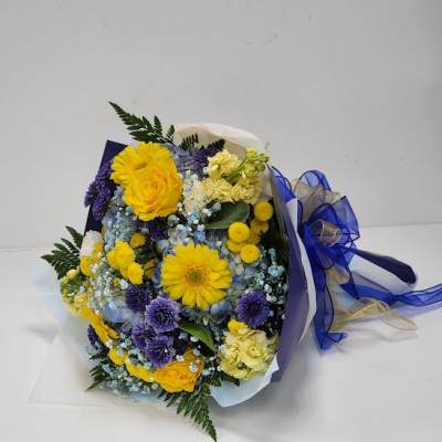 Bouquet of yellow and purple flowers wrapped in blue ribbon